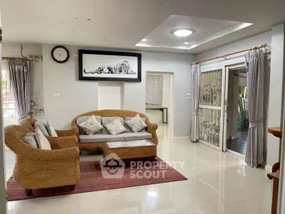 Spacious living room with wicker furniture and large sliding doors opening to a patio.