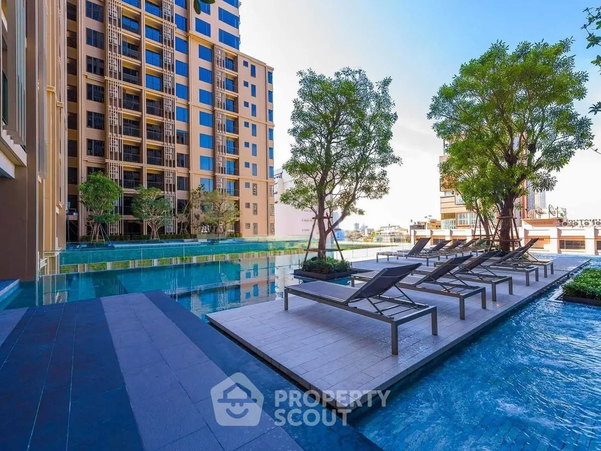 Luxurious urban apartment complex with stunning poolside relaxation area and modern architecture.
