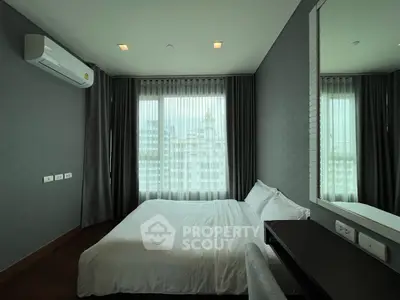 Modern bedroom with large windows and city view in a high-rise apartment.
