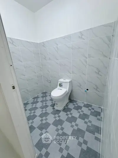 Modern bathroom with sleek tile design and contemporary toilet fixture.