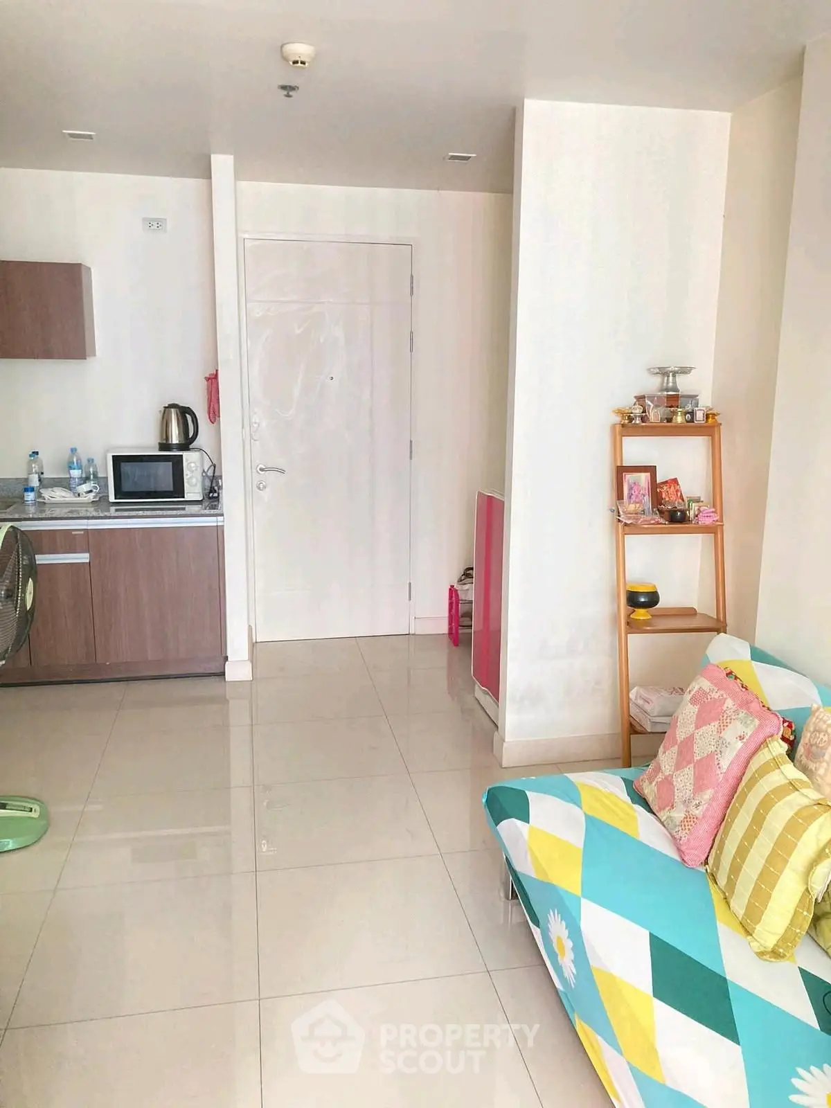 Cozy living room with colorful sofa and compact kitchen area