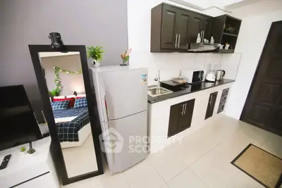 Modern kitchen with sleek cabinets and stainless steel appliances in a cozy apartment setting.
