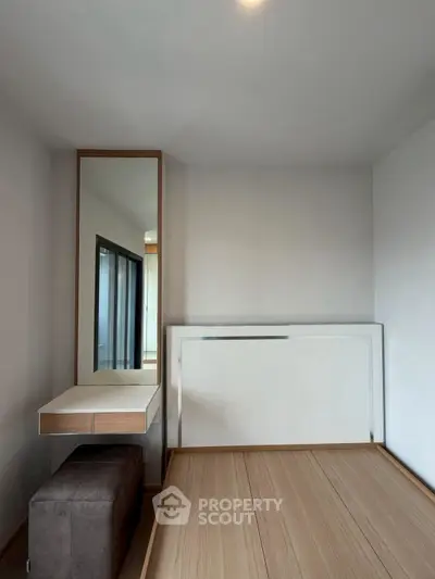 Modern minimalist bedroom with sleek furniture and ample natural light.