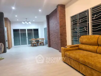 Spacious modern living room with stylish brick accents and cozy seating area.