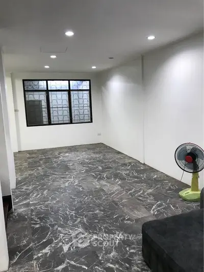 Spacious modern living room with marble flooring and large window, perfect for stylish urban living.