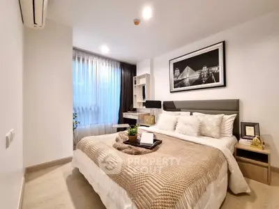 Modern bedroom with cozy decor and natural light, featuring a stylish bed and elegant furnishings.