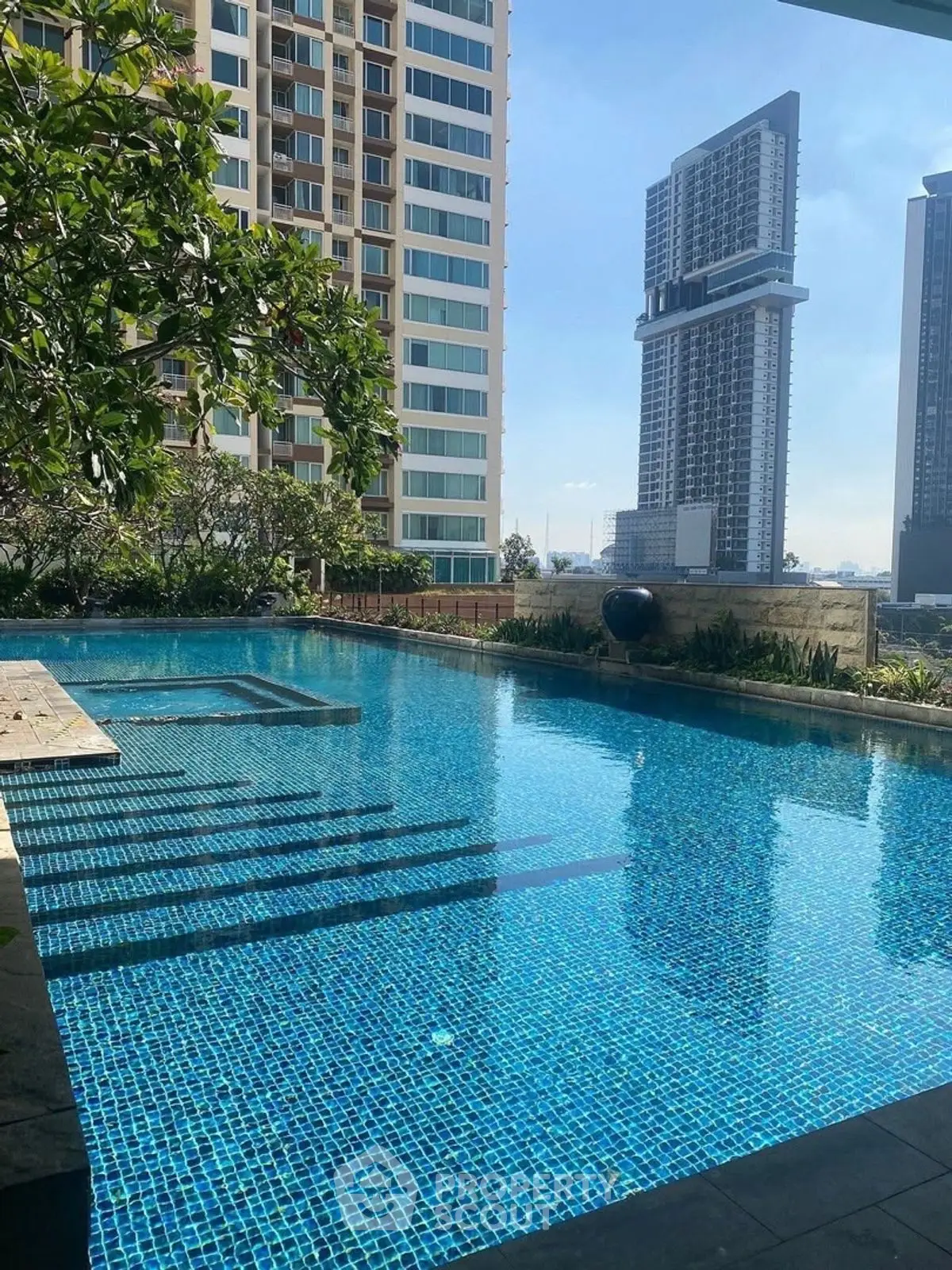 Luxurious rooftop pool with stunning cityscape views in modern high-rise building.