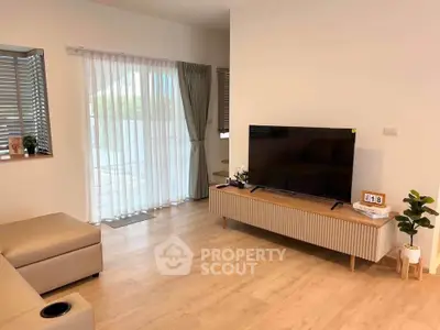 Modern living room with sleek TV stand, large window, and stylish decor