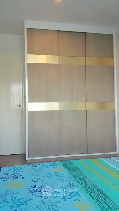 Modern bedroom with stylish wardrobe and colorful bedding
