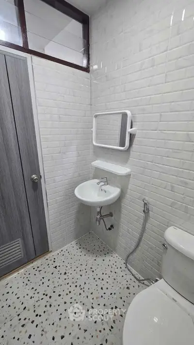 Modern bathroom with sleek white tiles and compact fixtures