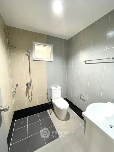 Modern bathroom with sleek tiles and contemporary fixtures in a real estate property.