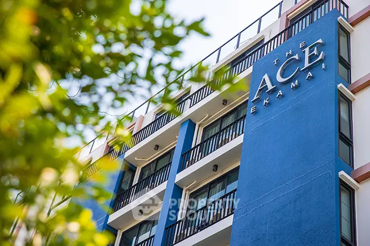 Modern blue apartment building with balconies in urban setting