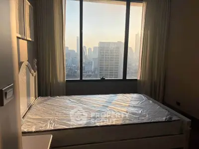 Spacious bedroom with city view and large window, perfect for urban living.