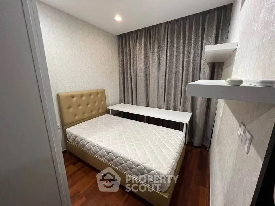 Cozy bedroom with elegant decor and wooden flooring, featuring a comfortable bed and stylish curtains.