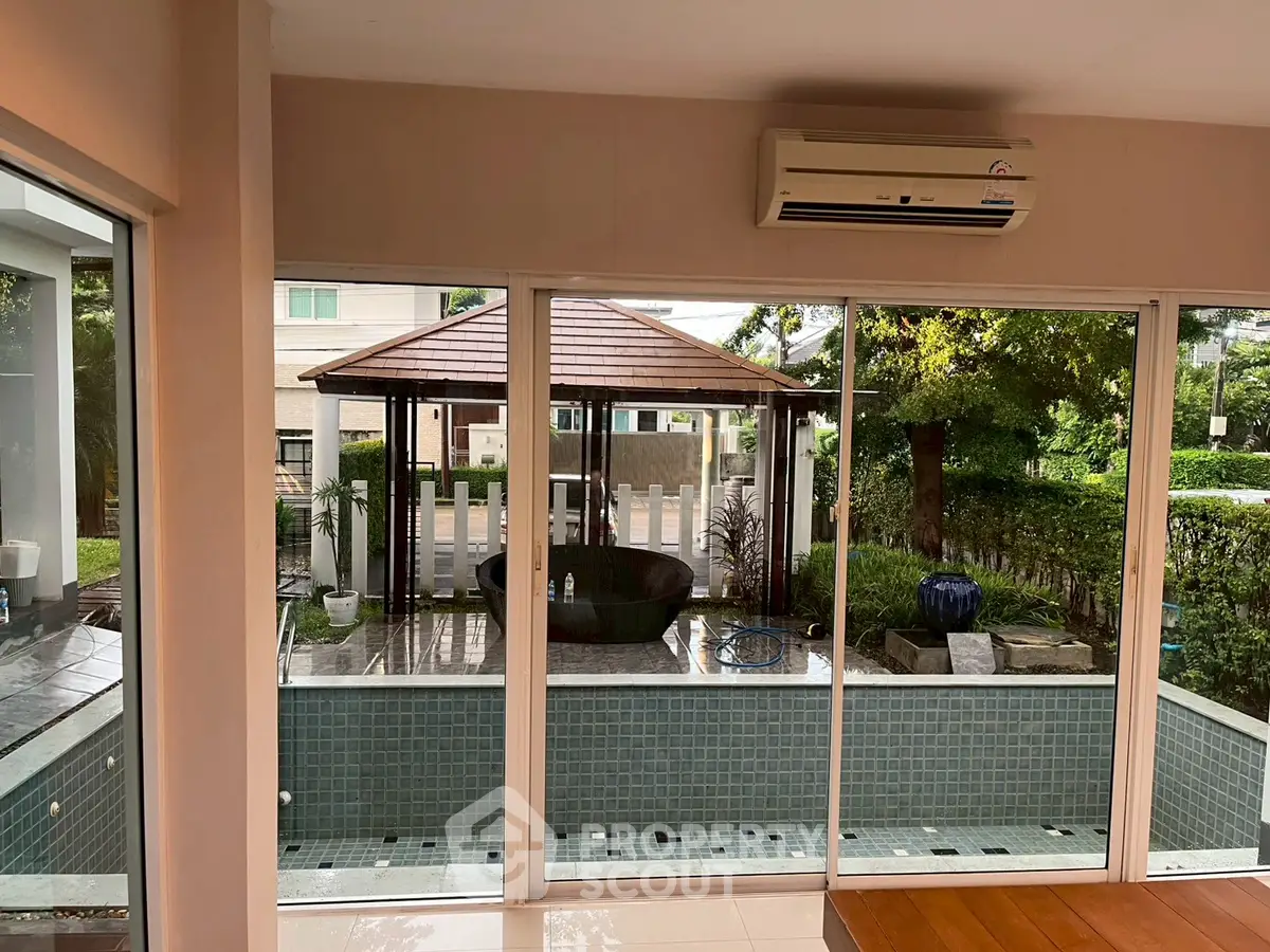 Spacious interior with pool view and outdoor gazebo, perfect for relaxation and entertainment.