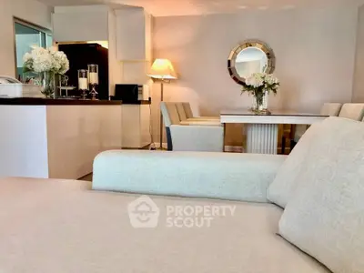 Elegant living room with modern decor and dining area, featuring plush seating and stylish lighting.