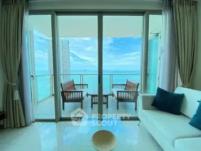 Luxurious living room with stunning ocean view and spacious balcony in modern high-rise apartment.