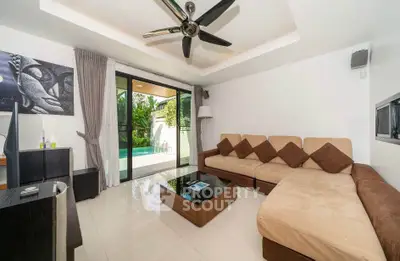 Spacious living room with modern decor and pool view, featuring a large sectional sofa and ceiling fan.