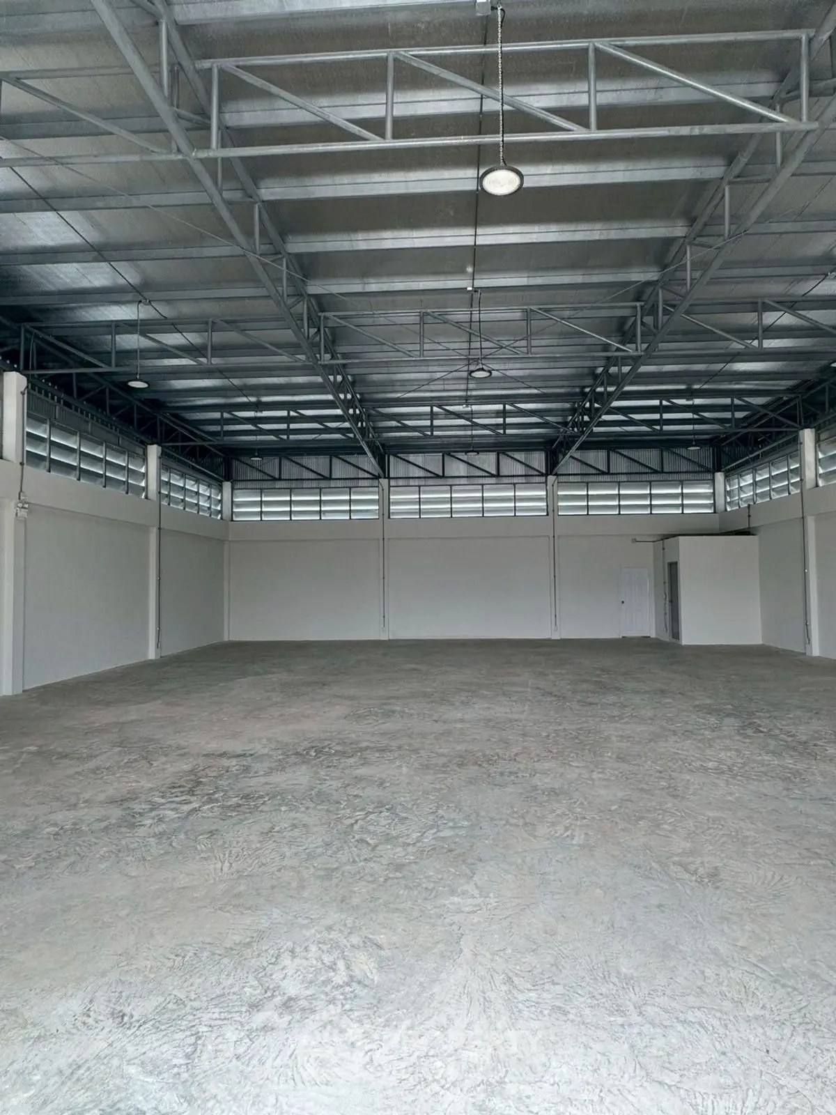 Spacious industrial warehouse with high ceilings and ample natural light.