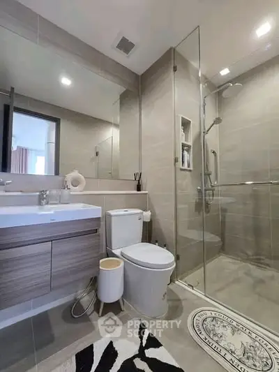 Modern bathroom with glass shower, sleek vanity, and stylish decor in a contemporary home.