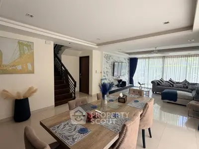 Spacious modern living room with elegant dining area and large windows for natural light.