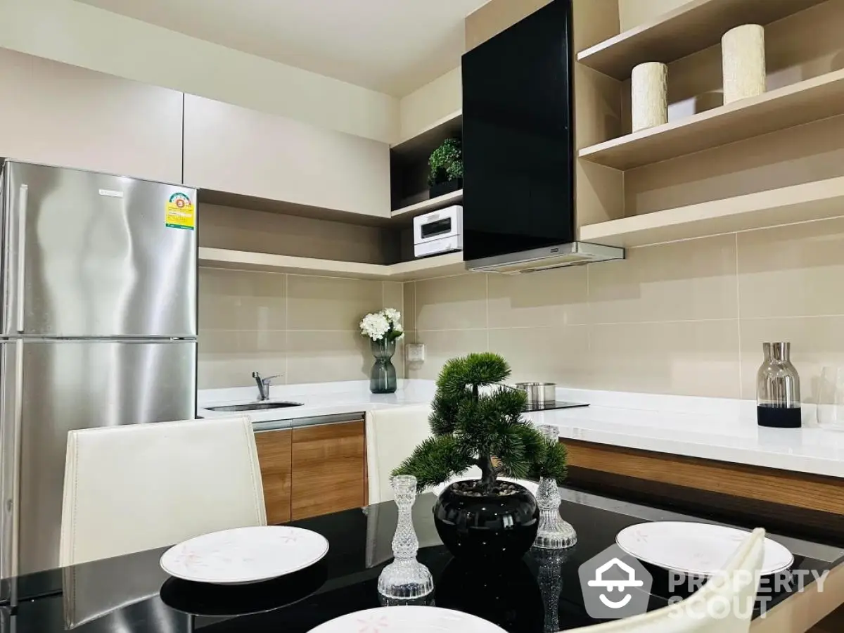 Modern kitchen with sleek design, stainless steel fridge, and elegant dining setup.