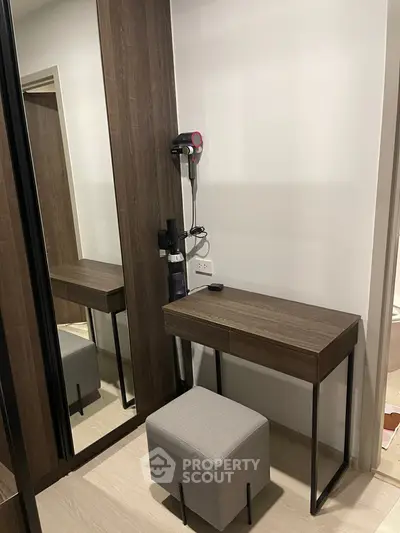 Modern bedroom with sleek vanity and mirror, featuring stylish decor and elegant design.
