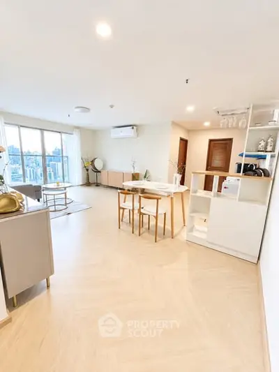 Spacious modern living room with dining area and large windows offering city views.