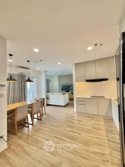 Spacious open-plan kitchen and dining area with modern design and wooden flooring.
