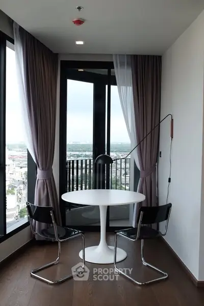 Chic modern balcony with city view, featuring elegant curtains and stylish seating area.