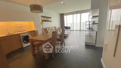 Spacious open-plan living and dining area with modern kitchen and natural light.