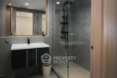 Modern bathroom with sleek shower and stylish vanity in contemporary home.