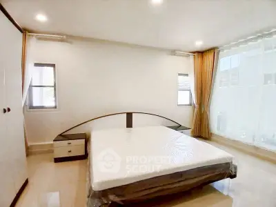 Spacious bedroom with large windows and modern furnishings