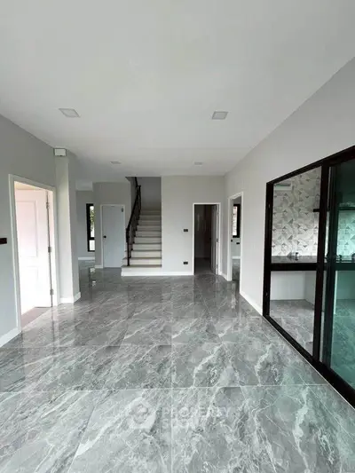Spacious modern living room with marble flooring and staircase, perfect for elegant living.