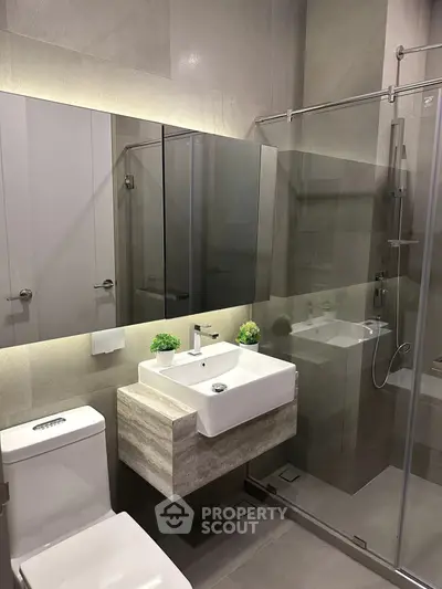 Modern bathroom with sleek design, glass shower, and stylish vanity in a contemporary home.