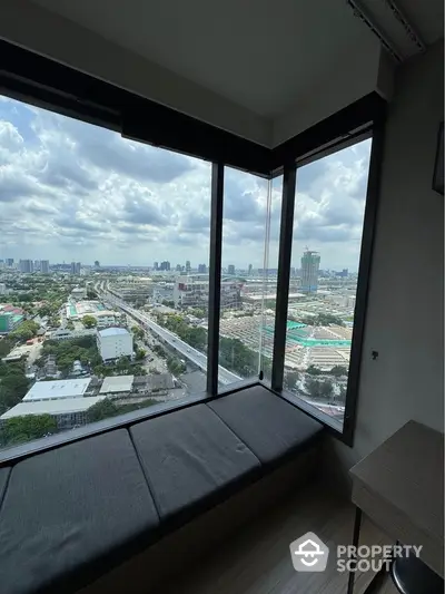 Stunning panoramic city view from high-rise apartment corner window.