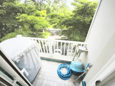 Charming balcony with lush green view, perfect for relaxation and outdoor enjoyment.