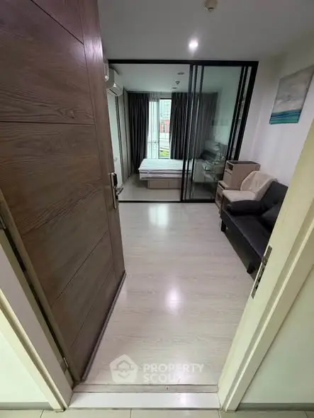 Modern apartment entrance leading to a cozy living area with a view of the bedroom.