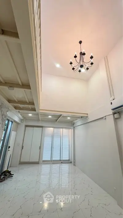 Spacious modern living room with high ceiling and elegant chandelier