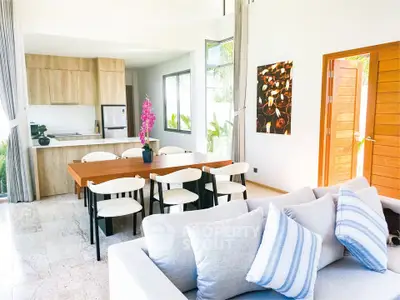 Spacious modern living room with open kitchen and elegant dining area, featuring stylish decor and natural light.