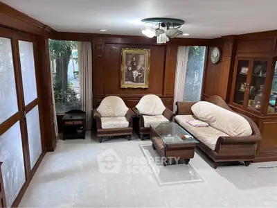 Charming living room with wooden paneling and cozy seating, perfect for relaxation and entertaining.