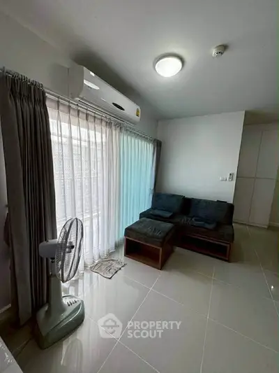 Modern living room with sleek tile flooring, cozy sofa, and large window with curtains.