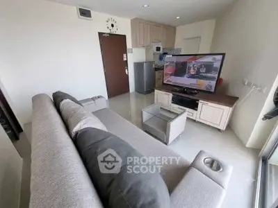 Modern living room with stylish furniture and large TV, perfect for relaxation and entertainment.