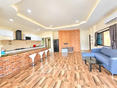 Spacious modern living room with open kitchen and stylish brick accents