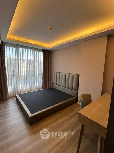 Modern bedroom with stylish lighting and large window in a contemporary apartment.