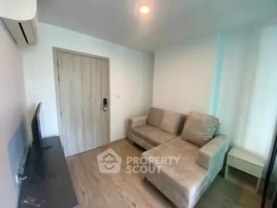 Cozy living room with modern sofa and flat-screen TV, perfect for relaxation.