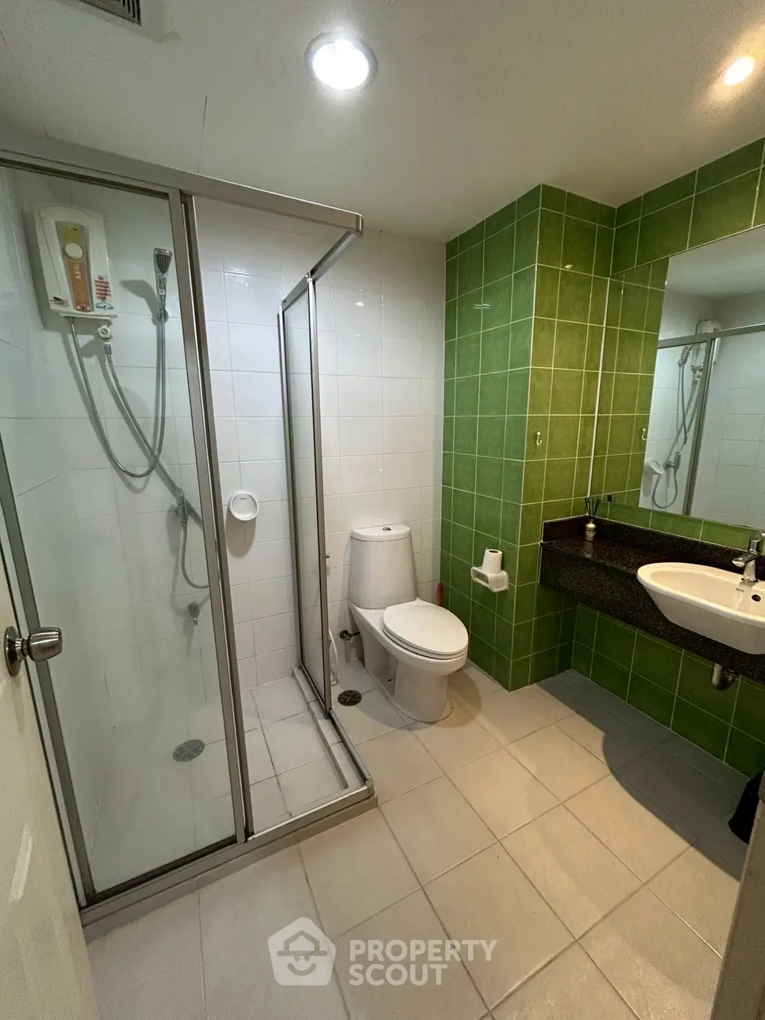 Modern bathroom with glass shower and green tile accent wall
