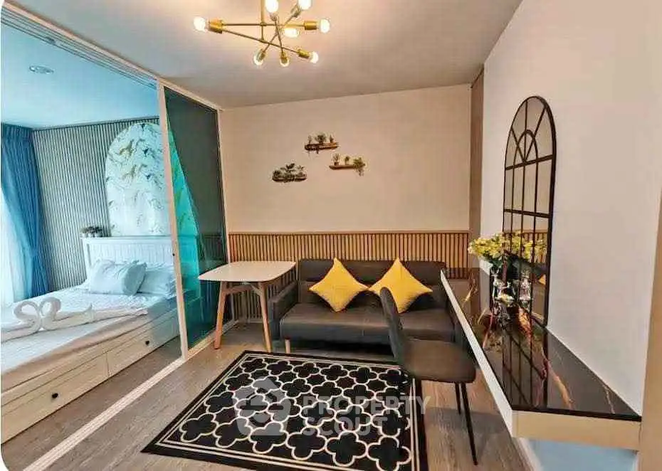 Stylish modern living room with elegant decor and cozy seating area, adjacent to a chic bedroom.