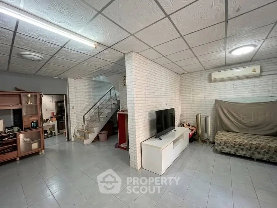 Spacious living room with modern decor and staircase, ideal for family gatherings.