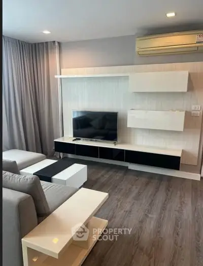 Modern living room with sleek furniture and wall-mounted TV in a stylish apartment.